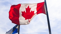 Le drapeau du Canada flottant devant celui de Québec